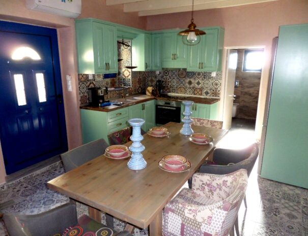 Ding Place with kichen in blue-turquoise colors, wooden table and chairs in Aspasias house in Zakros