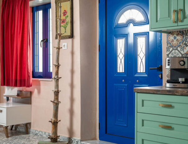 Blue door and window with red curtains, entrance at Aspasia's House in Zakros, Crete